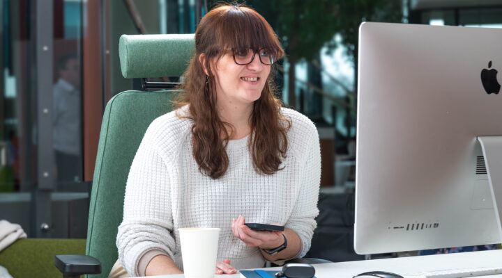 Woman smiling at computer desk.