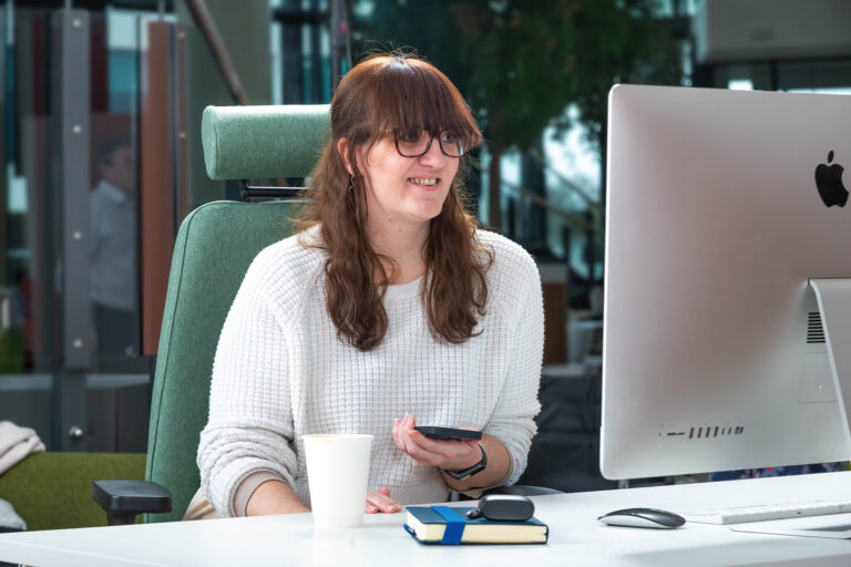 Woman smiling at computer desk.