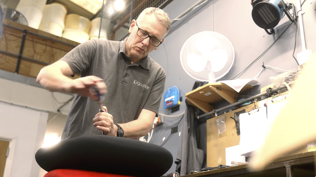Ergochair technician assembling an ergonomic chair by hand in the Ergochair manufacturing facility