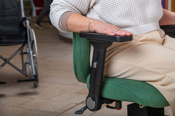 Close-up of an adjustable armrest on an Ergochair ergonomic chair with a person's arm resting on it