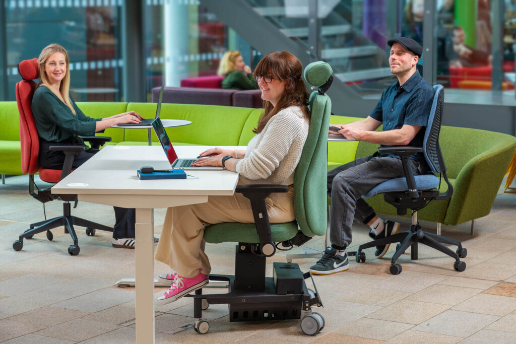 Three people working at desks seated in different Ergochair ergonomic chairs in a modern office environment
